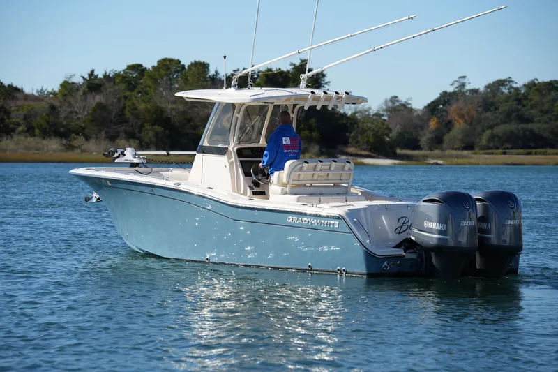 Slide: The Image of 2021 Grady-White Canyon 271 boat with dual Yamaha engines on a calm lake. - 13