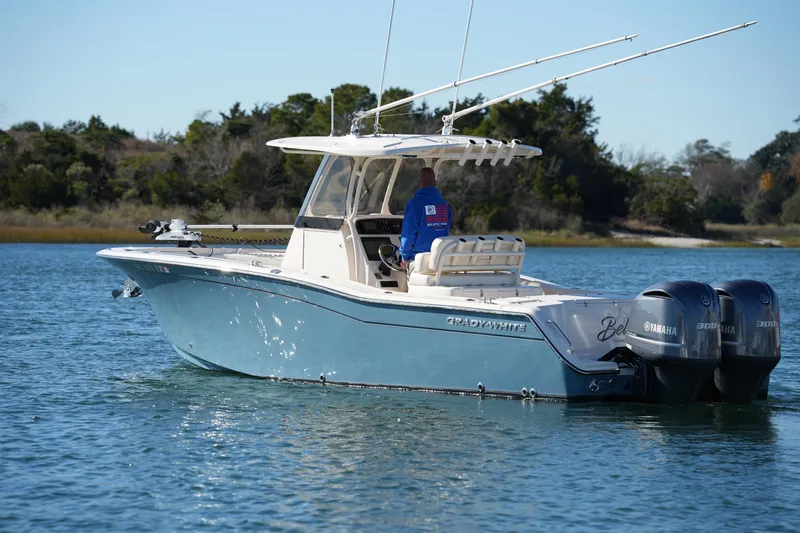 Slide: The Image of 2021 Grady-White Canyon 271 boat with dual Yamaha engines on a calm lake. - 14