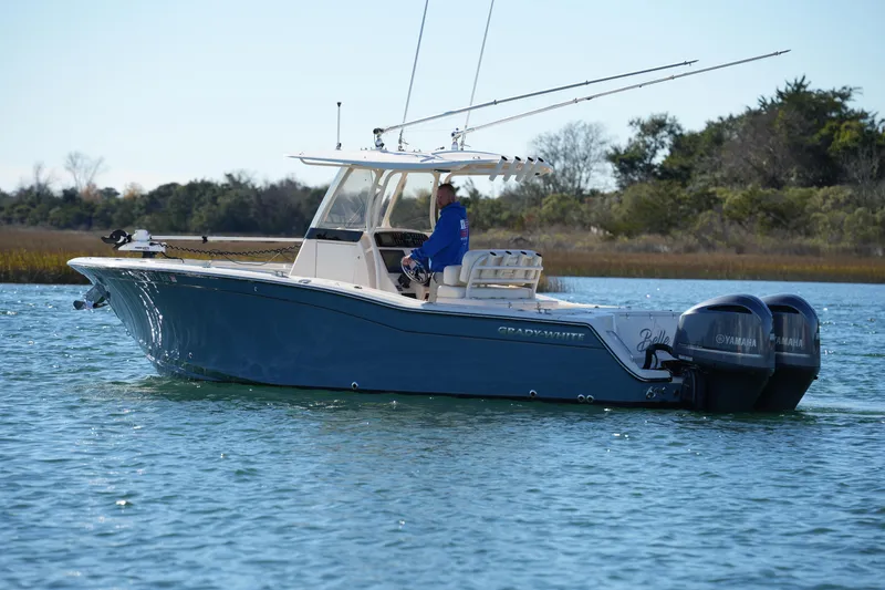 Slide: The Image of 2021 Grady-White Canyon 271 boat cruising on a serene waterway. - 19