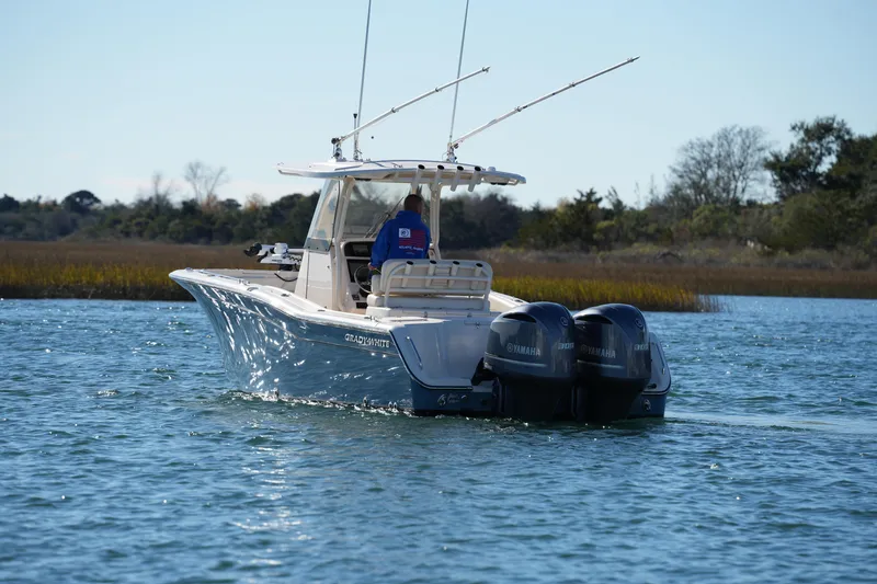 Slide: The Image of 2021 Grady-White Canyon 271 boat with dual Yamaha engines on a serene waterway. - 22