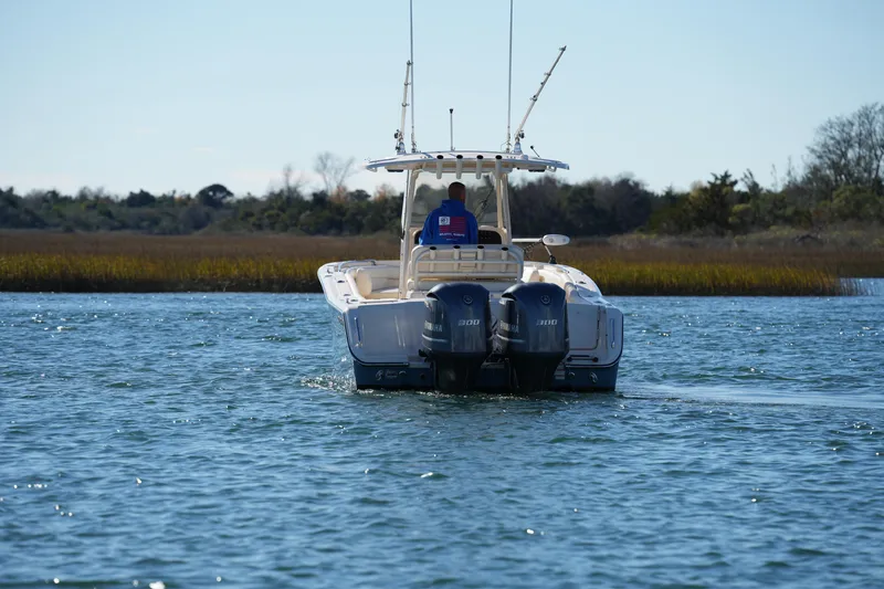Slide: The Image of 2021 Grady-White Canyon 271 boat cruising on a calm lake with dual engines. - 23