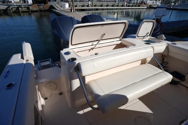 Slide: The Image of 2021 Grady-White Canyon 271 boat interior with open storage compartments at marina. - 26