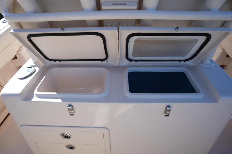 Slide: The Image of 2021 Grady-White Canyon 271 boat storage compartments with open lids. - 28