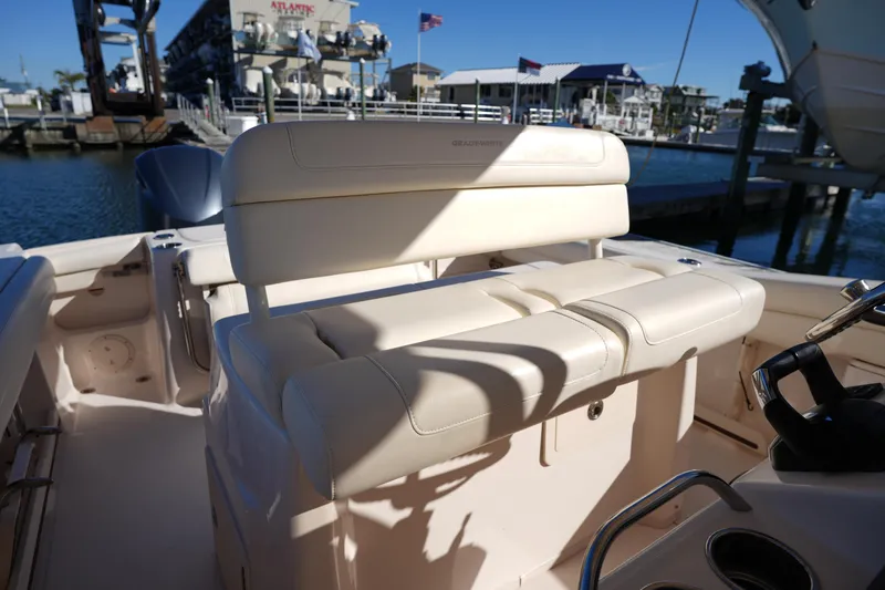 Slide: The Image of 2021 Grady-White Canyon 271 boat interior with seating and helm, docked at marina. - 30
