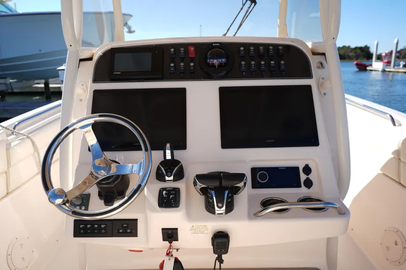 Slide: The Image of 2021 Grady-White Canyon 271 boat dashboard with steering wheel and controls. - 32
