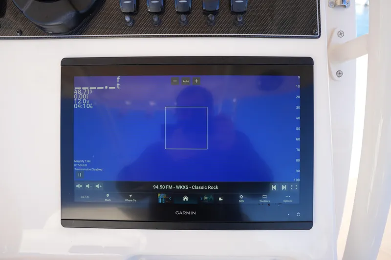 Slide: The Image of Garmin display on 2021 Grady-White Canyon 271 boat, showing navigation and radio controls. - 37