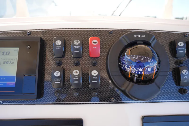 Slide: The Image of Control panel of 2021 Grady-White Canyon 271 boat with compass and switches. - 39