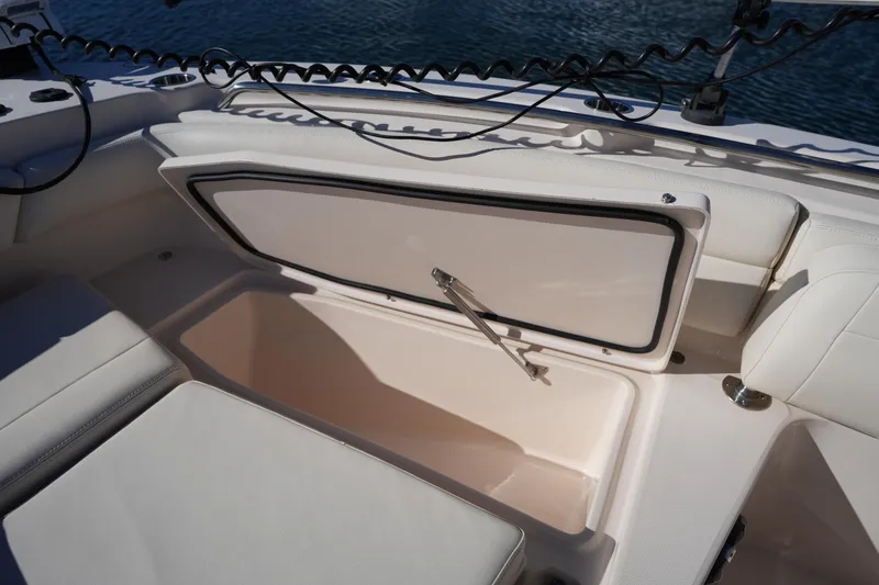 Slide: The Image of 2021 Grady-White Canyon 271 boat storage compartment with open hatch, white interior. - 48