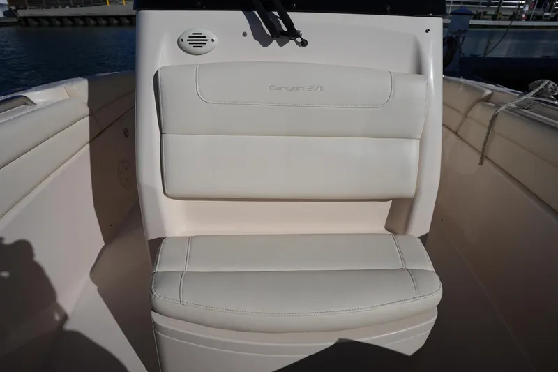 Slide: The Image of 2021 Grady-White Canyon 271 boat seat with beige upholstery, docked by the water. - 50