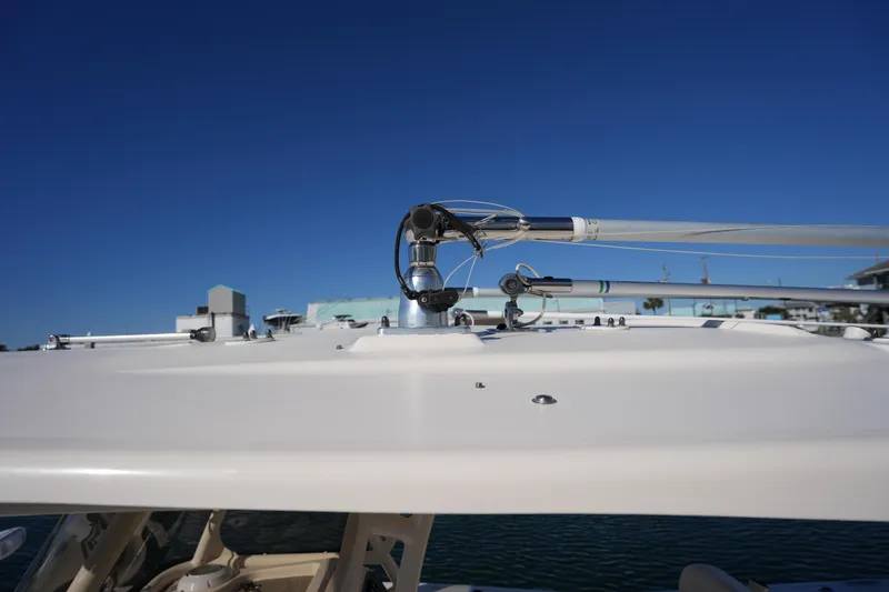 Slide: The Image of 2021 Grady-White Canyon 271 boat roof with fishing rod holders under clear blue sky. - 54