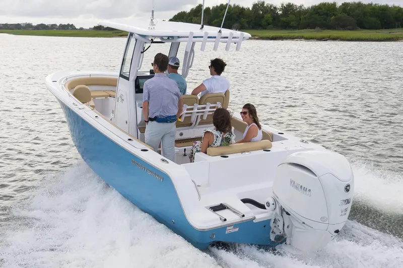 Slide: The Image of Manufacturer Provided Image: 2025 Sportsman Open 232 Center Console boat cruising on a lake with passengers. - 1