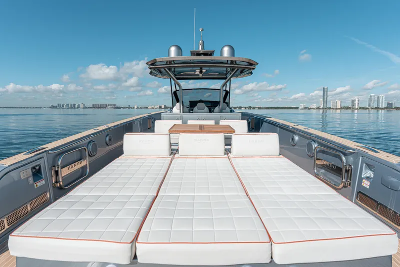 Slide: The Image of Luxury 2021 Pardo Yachts 43 with sunbathing deck, calm waters, and city skyline backdrop. - 17