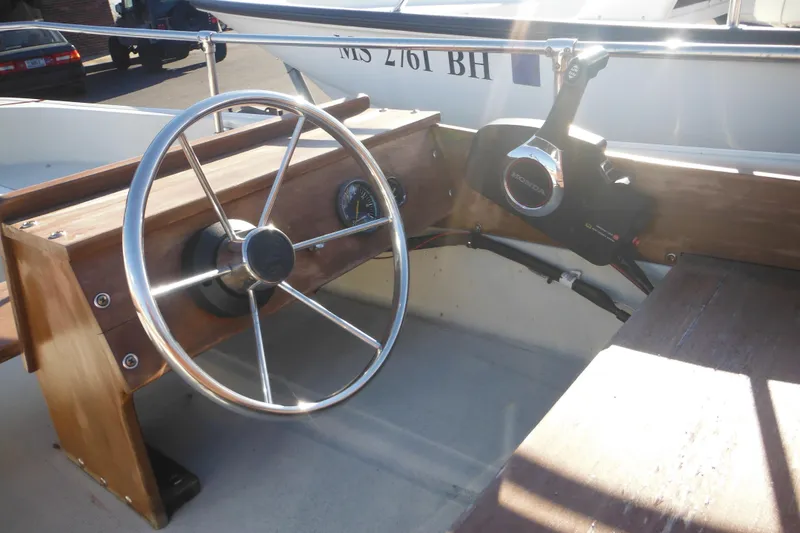 Slide: The Image of 1986 Boston Whaler 13 boat steering wheel and controls, featuring wooden dashboard. - 11