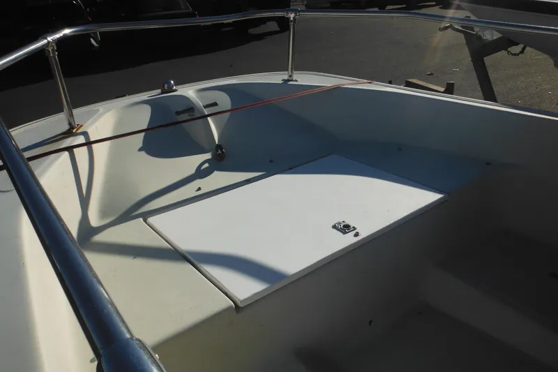 Slide: The Image of 1986 Boston Whaler 13 boat interior with white deck and metal railings. - 12