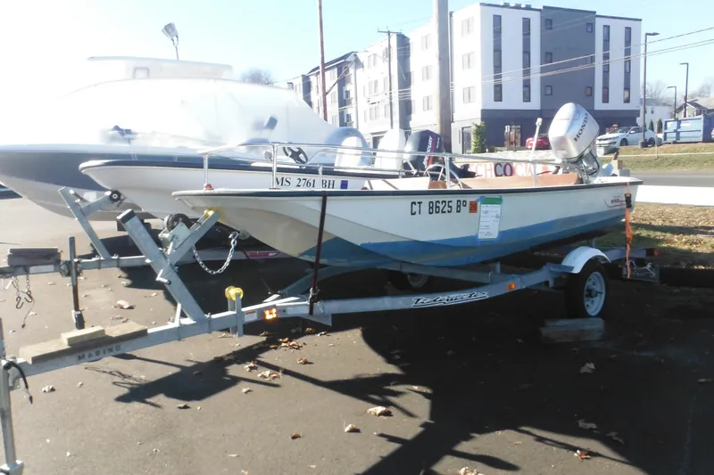 Slide: The Image of 1986 Boston Whaler 13 boat on trailer, parked outdoors near buildings. - 3
