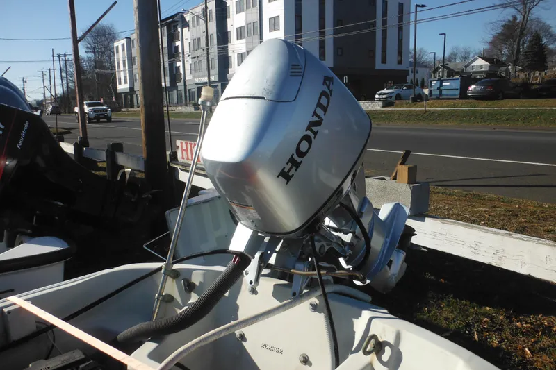 Slide: The Image of 1986 Boston Whaler 13 with Honda outboard motor, parked near a road. - 9