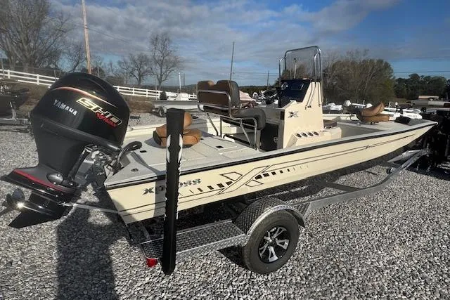 Slide: The Image of 2026 Xpress H20B Bay boat with Yamaha engine on a trailer, parked on gravel. - 12