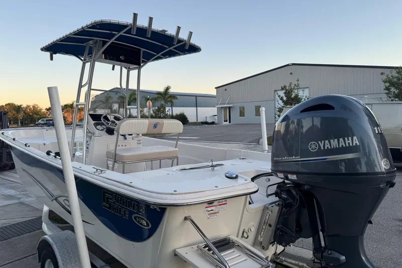 Slide: The Image of 2016 Carolina Skiff 198 DLV boat with Yamaha outboard motor, parked outdoors. - 11