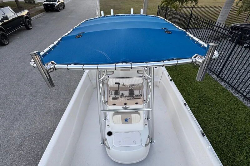 Slide: The Image of 2016 Carolina Skiff 198 DLV boat with blue canopy, parked on a street. - 22