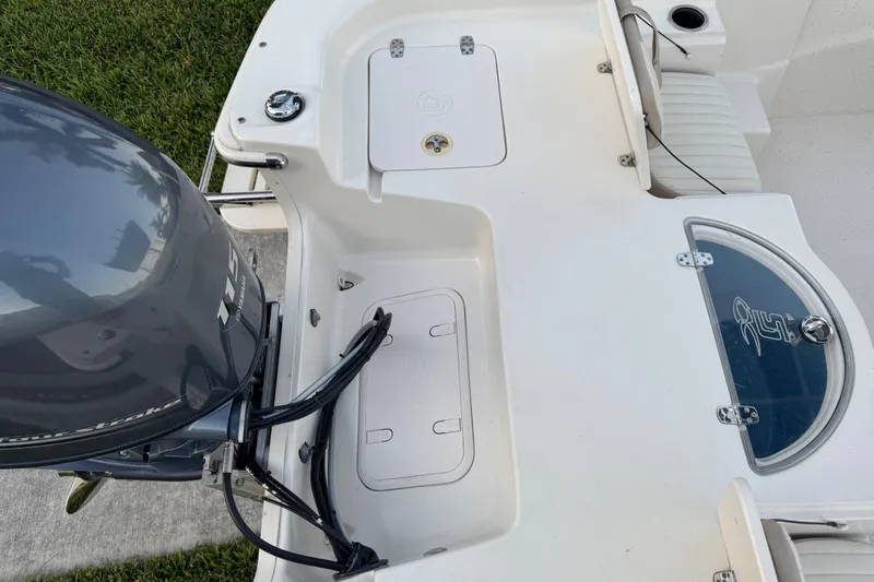 Slide: The Image of 2016 Carolina Skiff 198 DLV boat deck with motor and storage compartments. - 33