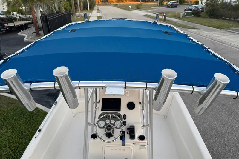 Slide: The Image of 2016 Carolina Skiff 198 DLV boat with blue canopy and rod holders. - 36