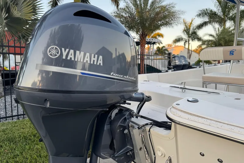 Slide: The Image of 2016 Carolina Skiff 198 DLV with Yamaha four-stroke engine, surrounded by palm trees. - 7