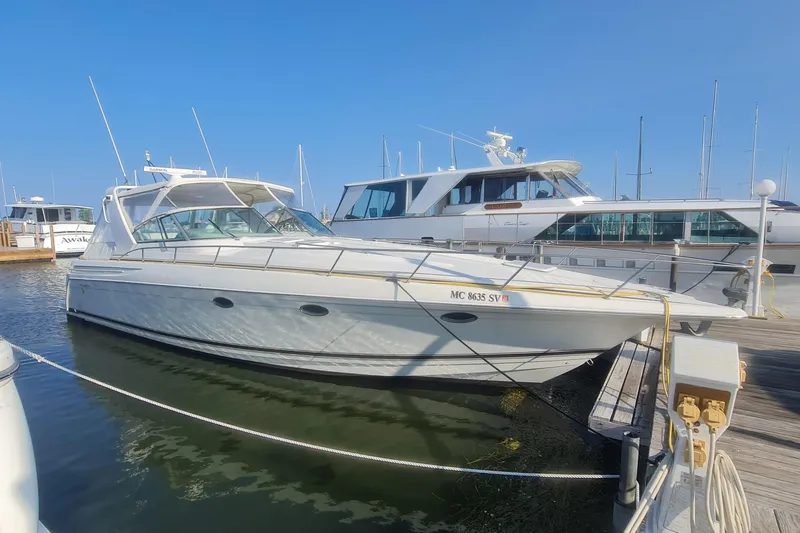 The Image of 1998 Formula 41 Performance Cruiser docked at marina under clear blue sky. - 0