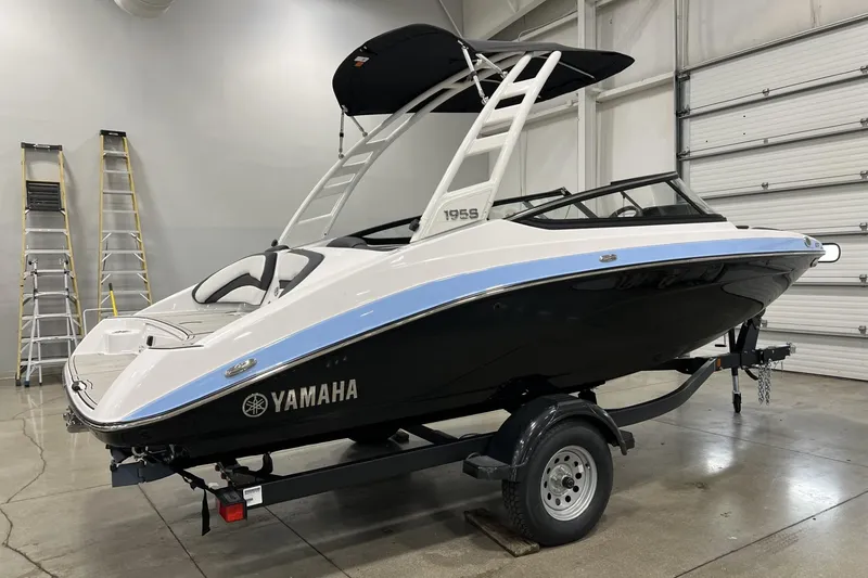 Slide: The Image of 2025 Yamaha Boats 195S in showroom, sleek design, black and white color scheme. - 2