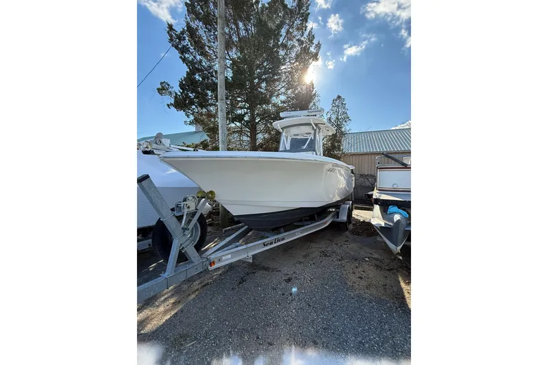 The Image of 2012 Tidewater 250 CC Adventure boat on trailer, parked outdoors under clear sky. - 1
