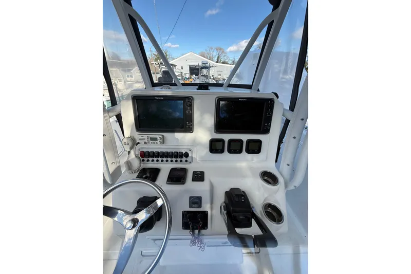 Slide: The Image of 2012 Tidewater 250 CC Adventure boat dashboard with navigation screens and controls. - 13