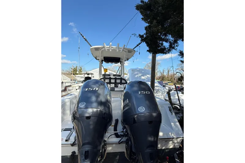 Slide: The Image of 2012 Tidewater 250 CC Adventure boat with dual Yamaha 150 engines, parked outdoors. - 5