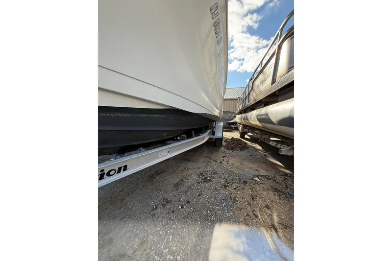 Slide: The Image of 2012 Tidewater 250 CC Adventure boat on trailer, parked outdoors under a blue sky. - 6