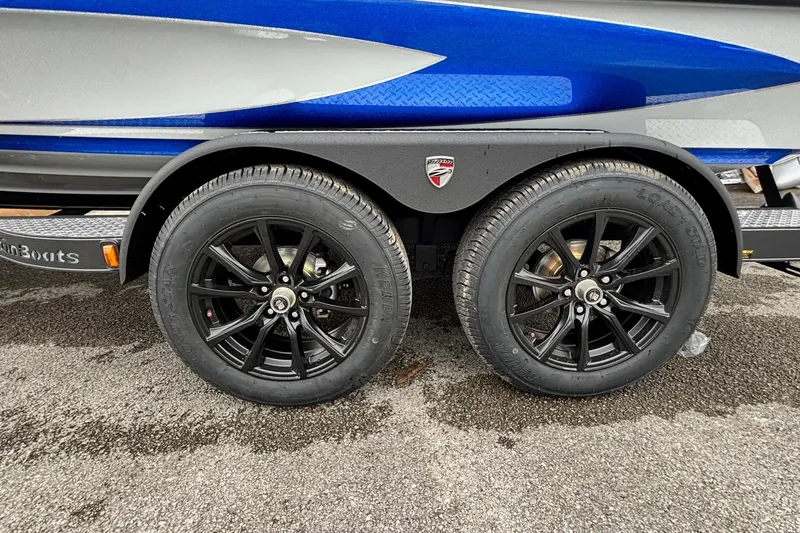 Slide: The Image of 2026 Triton 20XP Patriot boat trailer with black alloy wheels and blue accents. - 14