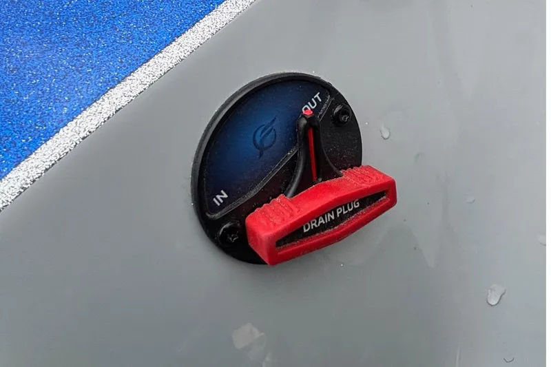 Slide: The Image of 2026 Triton 20XP Patriot drain plug with red handle on blue and gray surface. - 18