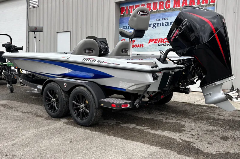 Slide: The Image of 2026 Triton 20XP Patriot boat with powerful engine, parked outside dealership. - 19