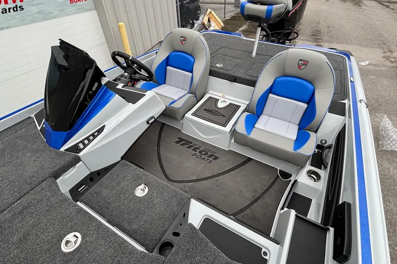 Slide: The Image of 2026 Triton 20XP Patriot boat interior with blue and gray seating, modern dashboard, and spacious layout. - 9