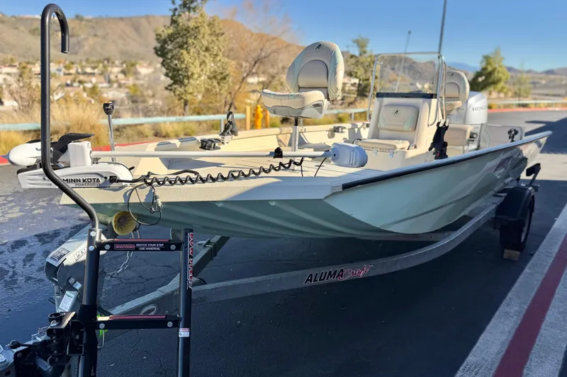 Slide: The Image of 2020 Alumacraft 2072 Bay boat on trailer, featuring Minn Kota motor, parked outdoors. - 3