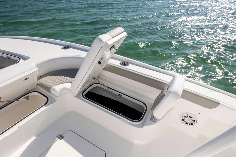 Slide: The Image of 2026 Caymas 26 HB boat with open storage compartment on deck, near sparkling water. - 13
