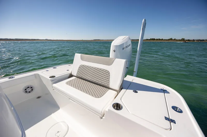 Slide: The Image of 2026 Caymas 26 HB boat with cushioned seating on open water. - 24