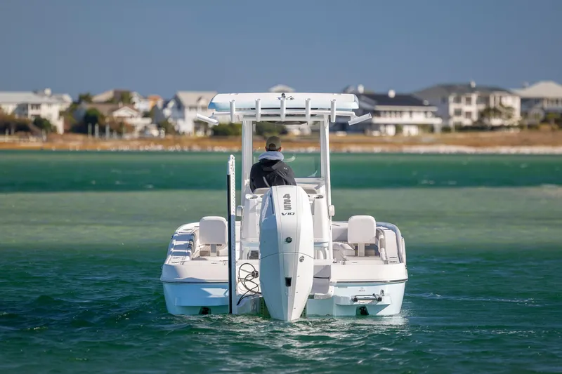 Slide: The Image of 2026 Caymas 26 HB boat cruising on clear blue water near coastal homes. - 3