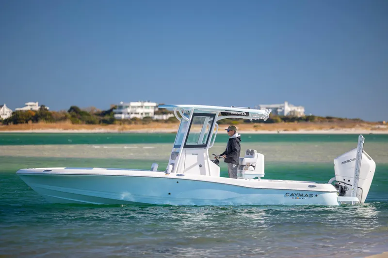 Slide: The Image of 2026 Caymas 26 HB boat cruising on clear waters near a sandy shoreline. - 5