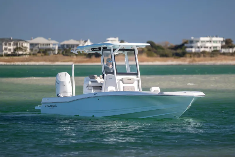 Slide: The Image of 2026 Caymas 26 HB boat cruising on turquoise waters near a coastal area. - 8
