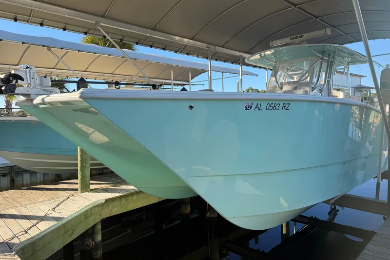 The Image of 2013 Freeman 33 boat on trailer, light blue hull, parked outdoors. - 0