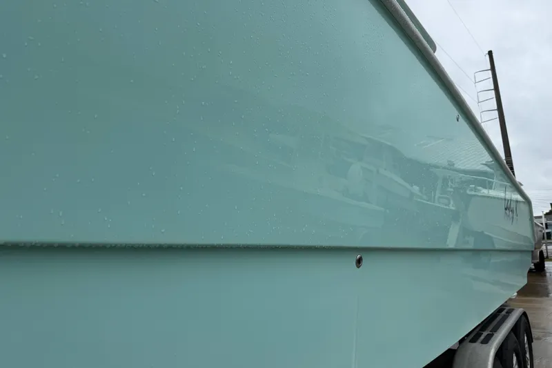 Slide: The Image of Side view of a 2013 Freeman 33 boat with a sleek, light blue hull. - 82