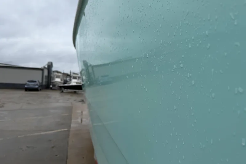 Slide: The Image of Close-up of a 2013 Freeman 33 boat hull with raindrops, parked in a marina. - 85