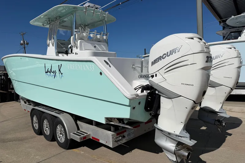 Slide: The Image of Freeman 33 boat, 2013 model, with dual Mercury Verado engines on a trailer. - 86