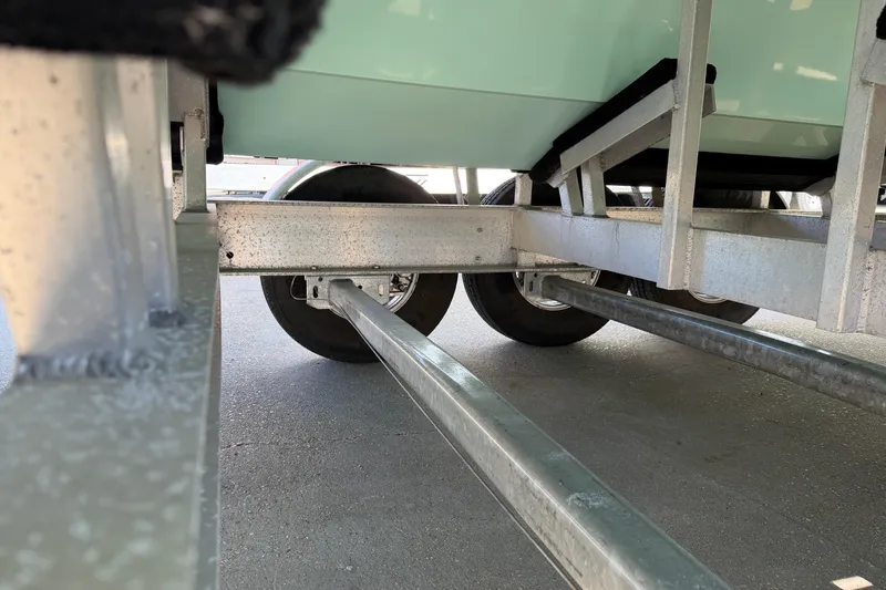 Slide: The Image of Underneath view of a 2013 Freeman 33 boat trailer, showcasing wheels and metal framework. - 94