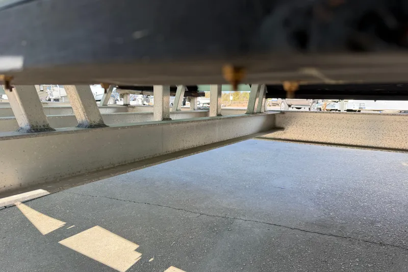 Slide: The Image of Underneath view of Freeman 33 boat trailer, 2013 model, on a paved surface. - 98