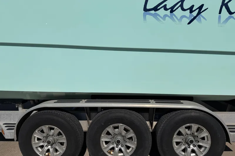 Slide: The Image of Trailer with Freeman 33 boat, 2013 model, featuring triple axle wheels. - 99