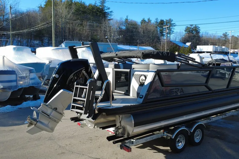 Slide: The Image of 2026 Alera M23Q pontoon boat on trailer, featuring a powerful outboard motor. - 3